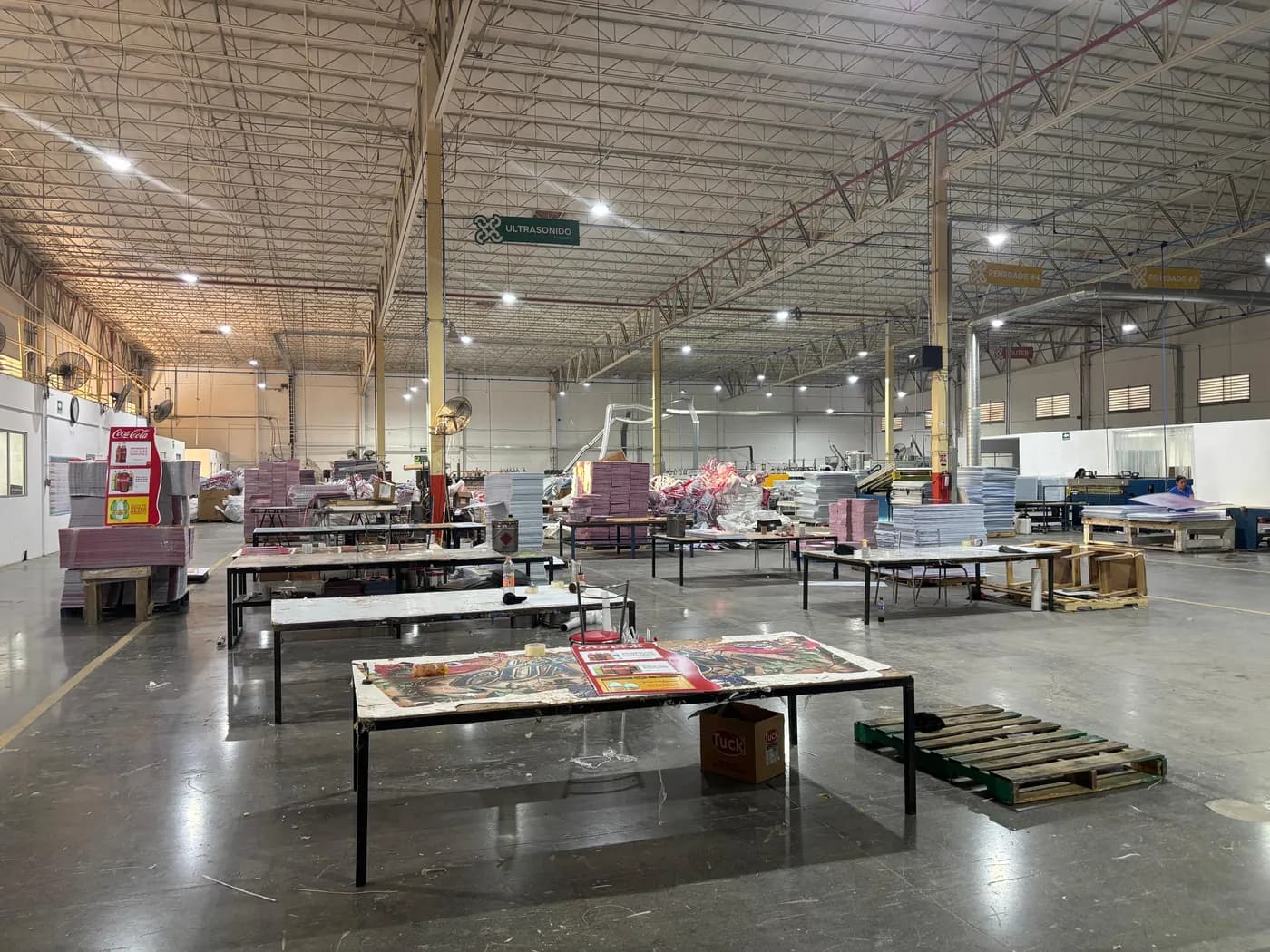 Nave de producción de Cassium con mesas de trabajo y lámina corrugada terminada